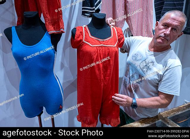 29 June 2023, Mecklenburg-Western Pomerania, Heringsdorf: Jürgen Kraft, swimwear collector, shows a swimsuit from the 1910s in the experience exhibition in the...