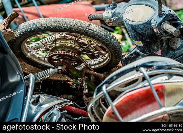 Yangshuo, China - August 2019 : Used, old, damaged and disposed of motorbikes, motorcycles and scooters piled up in the yard outside metal recycling plant in...
