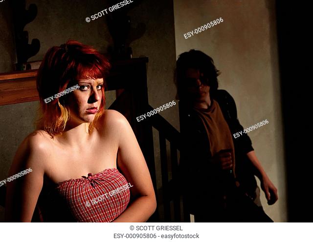 Frightened young woman with menacing alcoholic man