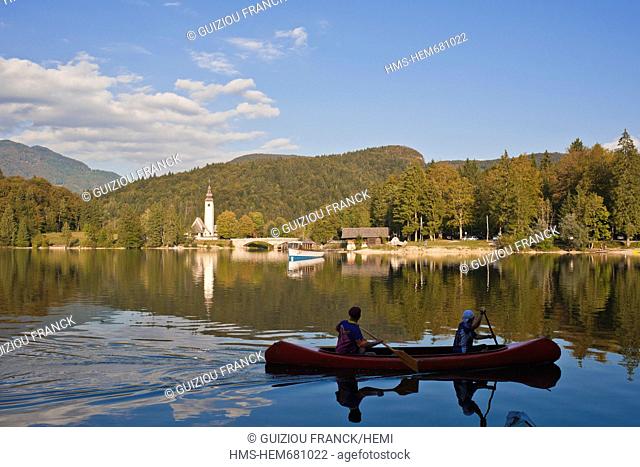 Slovenia, Goriska Region, Bovec, the Triglav National Park, canoeing on the Bohinj lake and St John the Baptist church in the background