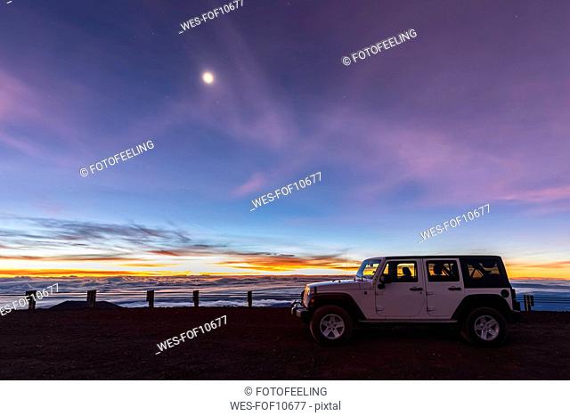 USA, Hawaii, Mauna Kea volcano, off road vehicle at dawn with full moon