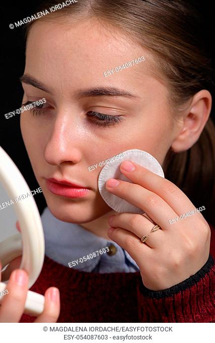 Girl Wipes Her Face With A Cotton Pad in Mirror
