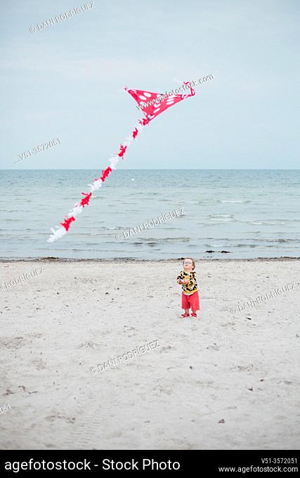 2 years old boy playing with a kite at the beach