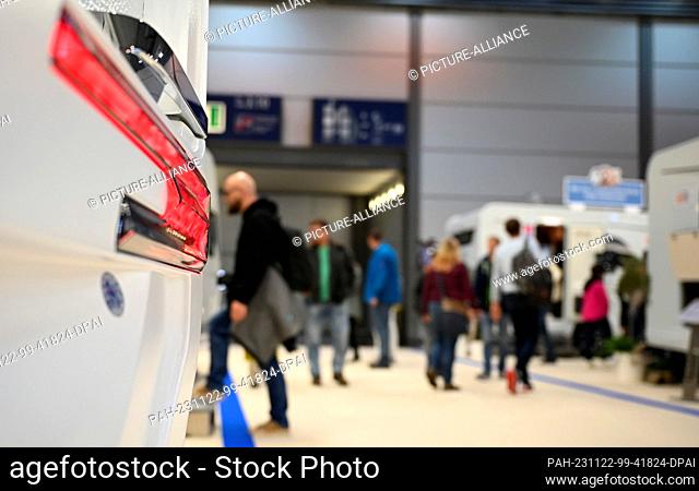 22 de noviembre de 2023, Sajonia, Leipzig: Visitantes de la feria ""Touristik " Caravaning International 2023"" a través de un pasillo con autocaravanas en...