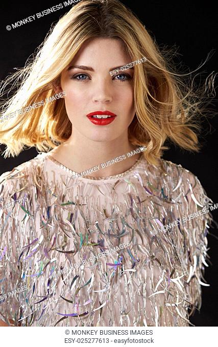 Glamorous blonde woman with hair blowing, vertical portrait