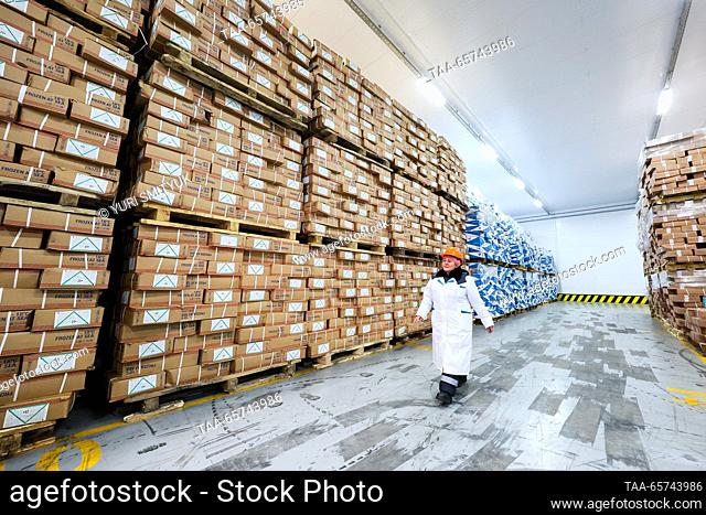 RUSSIA, VLADIVOSTOK - DECEMBER 14, 2023: A staff member walks past rows of cargo stacked on pallets at the Vladivostok Sea Fishing Port on Russia's Pacific...