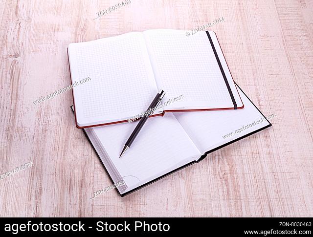 blank notebook with pen on wooden table, business concept