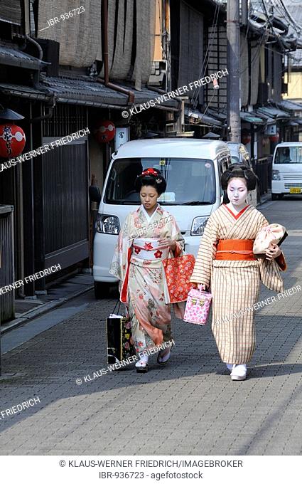 Maikos, Geisha apprentices, in the Gion quarter in Kyoto walking to Odori performance, Japan, Asia