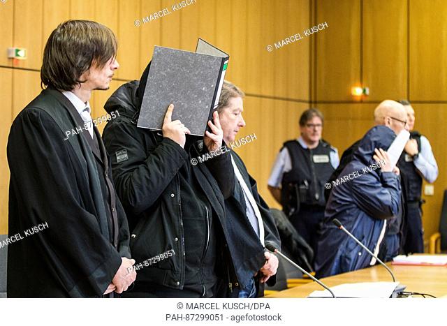 Defendants Ruediger D. (2.f.l) and Liana D. (5.f.l) hide their faces in the courtroom at the regional court in Bochum, Germany, 18 Janaury 2017