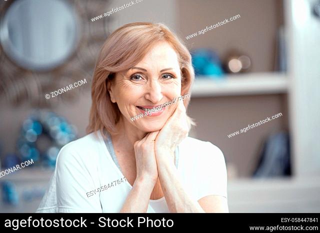Close Up of a Beautiful Woman Over 50 Years Old. Putting Your Hands to the Face She is Smiling Sweetly. Woman Enjoys Yoga. She Looks After Her Health