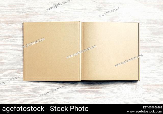 Book or brochure with blank craft paper pages on light wooden background. Mockup for placing your design. Flat lay