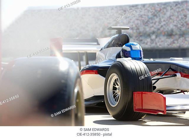 Formula one race car and driver in pit lane