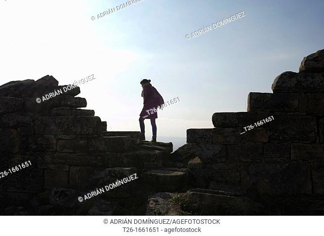 Person walking across stone wall in Pamukale, Turkey