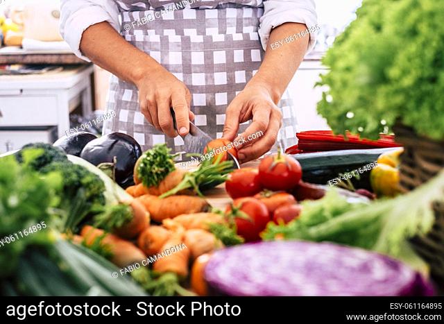 Close up of woman cutting fresh vegetables on the table. Chef at work in restaurant. Housewife preparing food for lunch at home