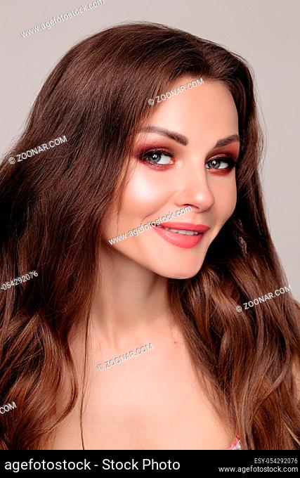 Close-up portrait of gorgeous pretty brunette caucasian young woman with bright smokey eyes and perfect skin looking at camera