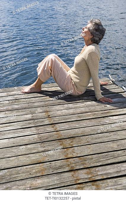 Senior woman sitting on dock