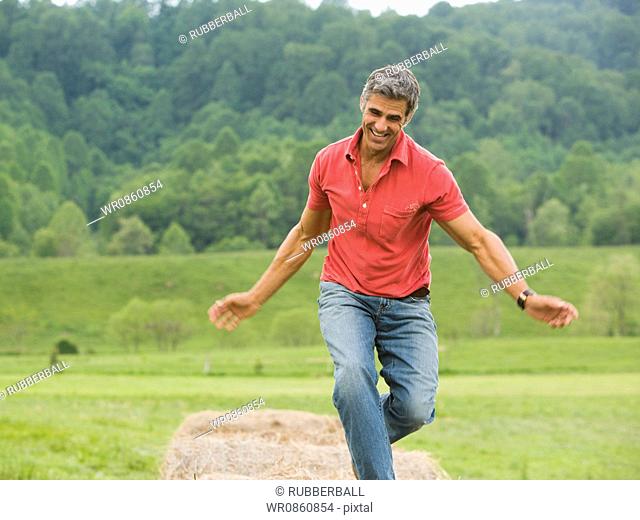 man dancing on a hay bale