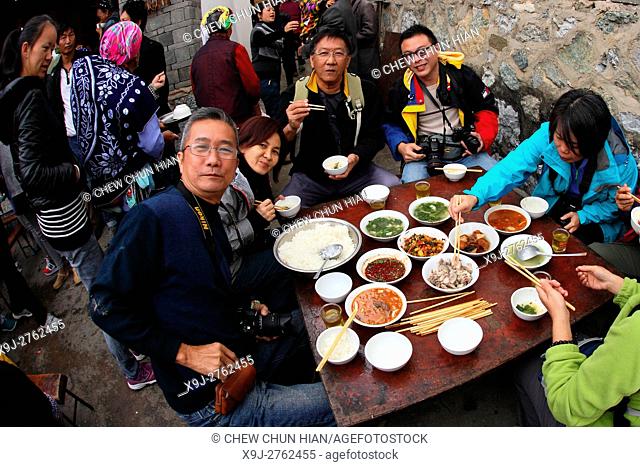 Family and friends having lunch togather for some celebration in Bei people's village in Dali, yunnan province, china