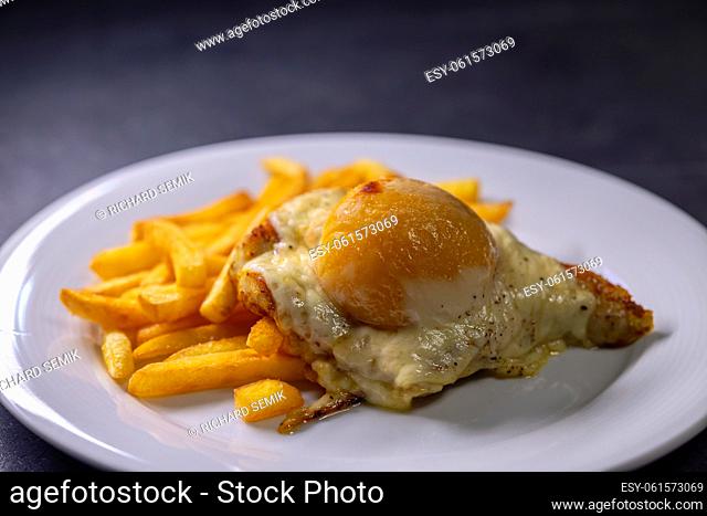 chicken steak baked with cheese and peach served with french fires