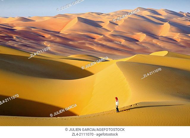 Woman in the sand dunes of the empty quarter desert. United Arab Emirates, UAE, Abu Dhabi, Liwa Oasis, Moreeb Hill, Tal Mireb. Model Released
