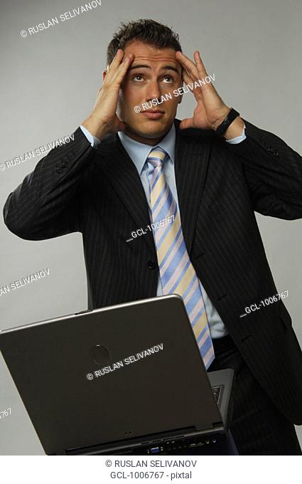 Businessman holding his head while looking up