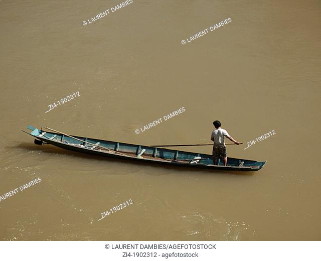 Fisherman on his boat paddling on the Mekong River in Luang Prabang Laos