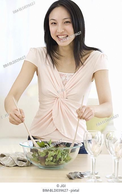 Asian woman making salad