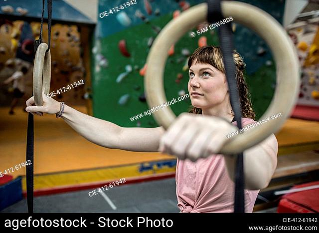 Determined young woman at gymnastics rings