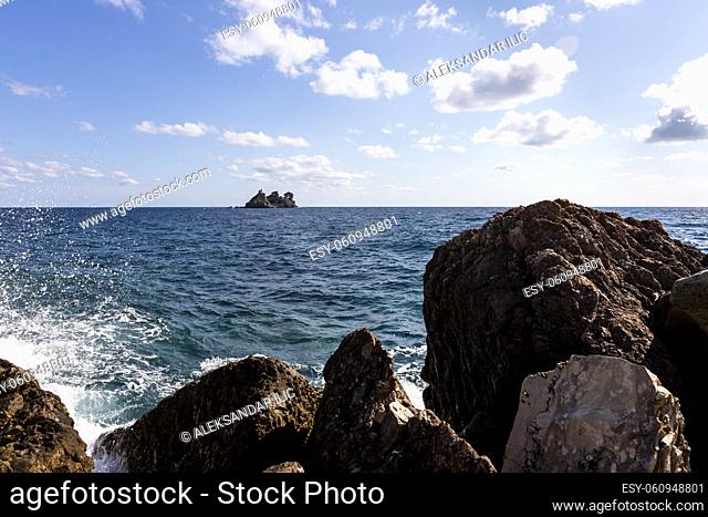View of island called Sveta Nedelja (St. Sunday) near Petrovac, Montenegro through the rock and splashing waves