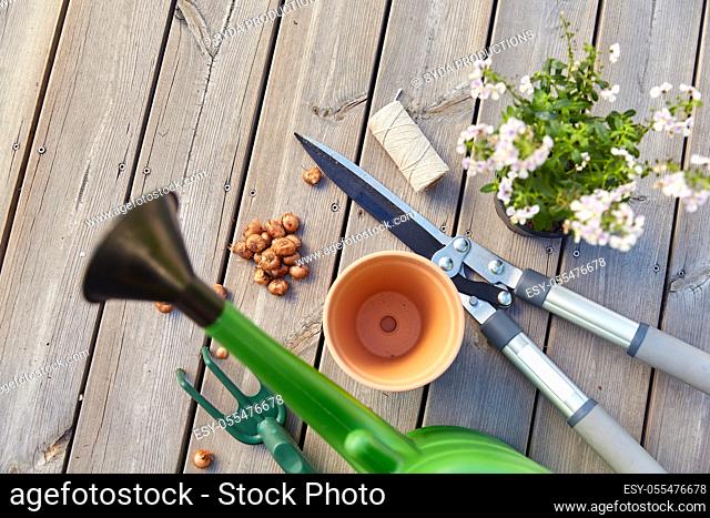 garden tools and flowers on wooden terrace