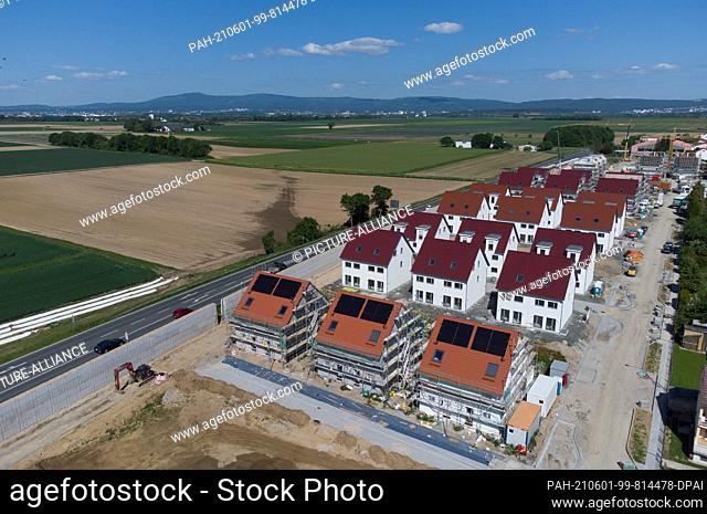 31 May 2021, Hessen, Nieder-Erlenbach: Only a road separates the new housing estate in the Frankfurt district of Nieder-Erlenbach from the farmland