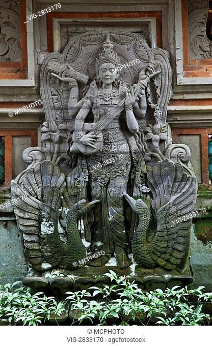 A stone carving of SARASWATI, the goddess of knowledge, music and the arts at the entrance of PURA DESA - UBUD, BALI, INDONESIA - 07/12/2010