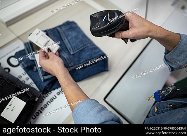 ILLUSTRATION - 02 March 2022, Berlin: An employee scans several pairs of jeans at the C&A clothing store in a shopping center in Berlin-Marzahn
