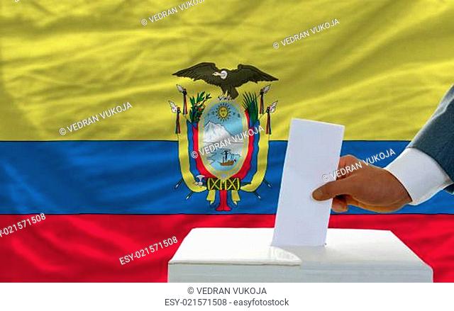 man voting on elections in ecuador in front of flag