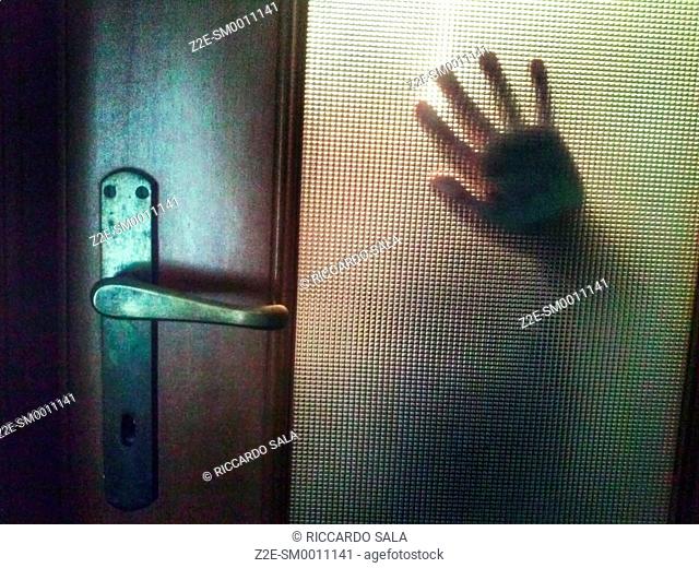 Hand Behind Door Glass