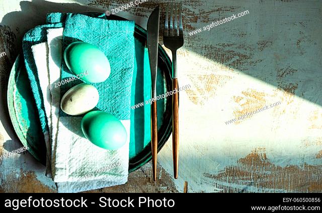 Easter table setting with eggs on wooden background with copy space