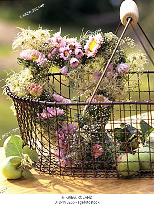Heart-shaped autumn arrangement of pink asters and gypsophila