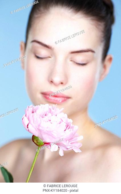 Young woman holding peony