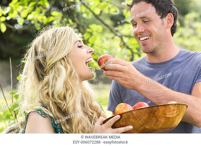 Young man feeding his girlfriend with an apple