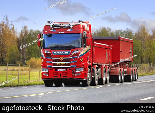 Red customised Scania R of Kuljetus Timo Šberg Oy pulls gravel trailer along highway 2 on a day of autumn. Tammela, Finland. October 16, 2020
