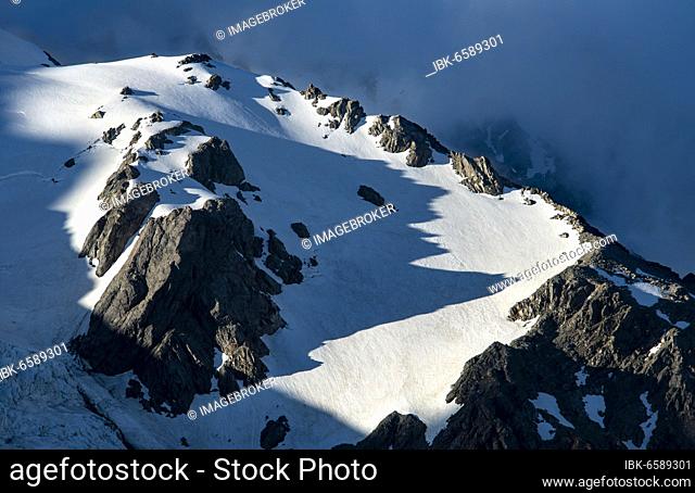 Snow covered rocky mountainside in evening light, Mount Sefton with Tucket Glacier and Huddelston Glacier, Mount Cook National Park, Canterbury Region