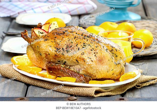 Roasted duck with oranges on wooden table. Festive dish