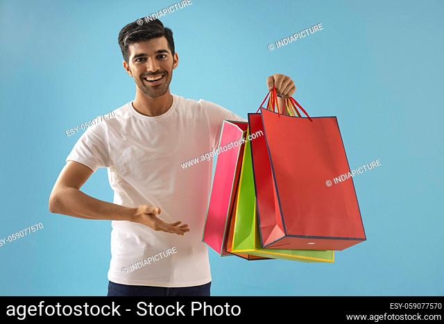 A young man pointing towards his carrybags