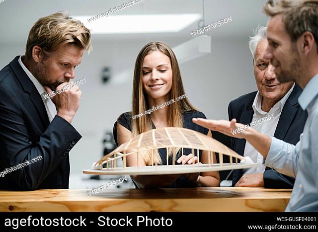 Successful business people looking at architectural model in office