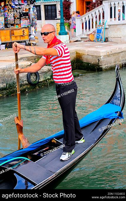 Man rowing gondola in Venice, Italy. Venice is situated across a group of 117 small islands that are separated by canals and linked by bridges