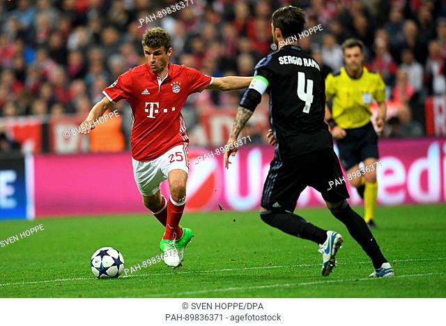 Munich's Thomas Mueller (l) and Madrid's Sergio Ramos during the first leg of the Champions League quarter final match between Bayern Munich and Real Madrid in...