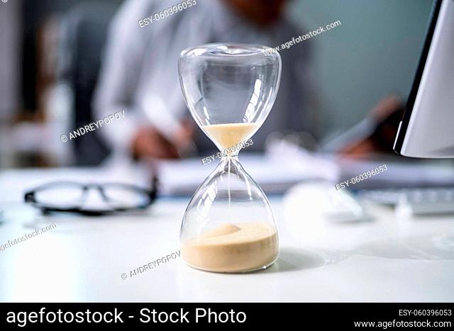 Late Invoice And Billing Deadline With Hourglass At Desk