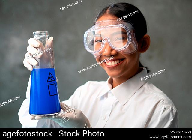 Chemical research scientist working in the lab with colorful liquids. Young female chemist doing science experiment with chemicals