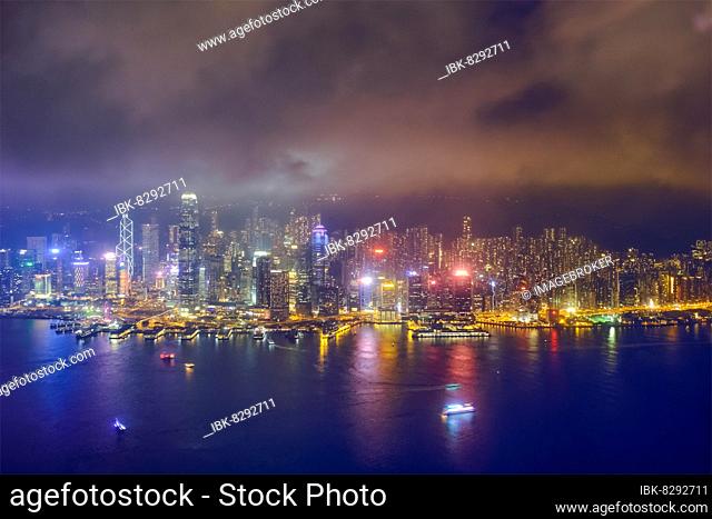 Aerial view of illuminated Hong Kong skyline cityscape downtown skyscrapers over Victoria Harbour in the evening. Hong Kong, China, Asia