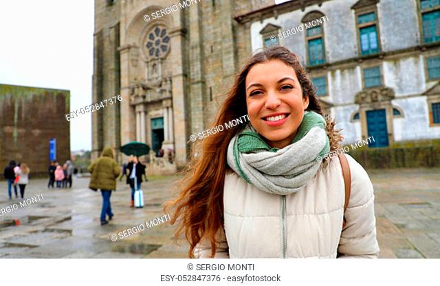 Young tourist woman standing in front of Porto Cathedral in raining day, Porto, Portugal